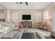 Comfortable living room featuring a ceiling fan, modern furniture, and large windows with shutters at 24275 N 173Rd Ave, Surprise, AZ 85387