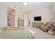 Bright main bedroom boasting soft carpet, neutral paint, furniture, and television for cozy evenings at 24275 N 173Rd Ave, Surprise, AZ 85387