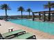 Community pool with chaise lounges and palm trees set against a backdrop of clear blue skies and distant mountains at 24275 N 173Rd Ave, Surprise, AZ 85387