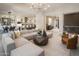 Open-concept living area, flowing into the dining room and kitchen, featuring a large sectional sofa at 24283 S 219Th Way, Queen Creek, AZ 85142