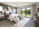 Serene main bedroom with a sitting area, large windows offering backyard views, and contemporary design elements at 24283 S 219Th Way, Queen Creek, AZ 85142