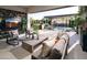 Relaxing covered patio featuring comfortable seating, a TV, a water feature, and views of the well-maintained backyard at 24283 S 219Th Way, Queen Creek, AZ 85142