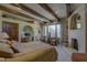 Comfortable main bedroom featuring exposed beams, fireplace, seating area, and built-in display shelving at 3119 Arroyo Hondo --, Carefree, AZ 85377