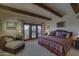 Comfortable main bedroom featuring exposed beams, a lounge chair, and French doors leading to a balcony at 3119 Arroyo Hondo --, Carefree, AZ 85377