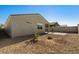 Back of house showcasing desert landscaping, backyard privacy fence, and covered patio at 34210 N Beeblossom Trl, San Tan Valley, AZ 85144