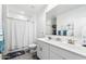 Light-filled bathroom features a double vanity with a shower-tub combo with a shower curtain at 34210 N Beeblossom Trl, San Tan Valley, AZ 85144