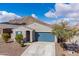 Inviting single-story home with blue garage door, shutters, and a low maintenance desert landscape at 34210 N Beeblossom Trl, San Tan Valley, AZ 85144