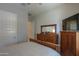 Bedroom with a wooden dresser, mirror, and door at 391 N San Ricardo Trl, Casa Grande, AZ 85194