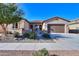 Inviting front exterior with a well-kept lawn, mature tree, and stone-accented entryway at 391 N San Ricardo Trl, Casa Grande, AZ 85194