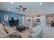 Open-concept living room featuring comfortable sofas, ceiling fan, and seamless flow to the kitchen at 391 N San Ricardo Trl, Casa Grande, AZ 85194