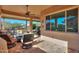 Relaxing covered patio features an outdoor ceiling fan, cozy furniture, and views of the desert landscape at 391 N San Ricardo Trl, Casa Grande, AZ 85194