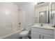 Clean bathroom with a white tiled shower, toilet, and vanity with a mirror at 4053 W Quail Ave, Glendale, AZ 85308