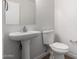 Clean half-bathroom with a pedestal sink, toilet, and brushed nickel fixtures at 4053 W Quail Ave, Glendale, AZ 85308