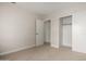 Bright bedroom featuring neutral carpeting, a closet, and a door leading to another room at 4053 W Quail Ave, Glendale, AZ 85308