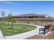 Community green space featuring walking paths and a bench with manicured landscaping and view of neighborhood homes at 41740 W Sonoran Trl, Maricopa, AZ 85138