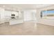 Inviting living room featuring neutral tile, natural light, and seamlessly connecting to a well-appointed kitchen at 41740 W Sonoran Trl, Maricopa, AZ 85138