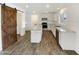 Modern kitchen with stainless steel appliances, granite countertops, and a stylish barn door to the pantry at 4360 E Sierrita Rd, San Tan Valley, AZ 85143