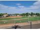 Community baseball field showing the sandlot, grassy areas, fencing and surrounding trees at 650 N Hawes Rd # 4326, Mesa, AZ 85207