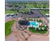 Aerial view of the community pool area, showcasing lounge seating, palm trees, and a clubhouse at 650 N Hawes Rd # 4326, Mesa, AZ 85207