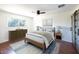 Bright bedroom featuring a ceiling fan, wood floors, and a large window that provides natural light at 6847 S Willow Dr, Tempe, AZ 85283