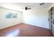 A simple bedroom with wood floors, white walls, and a ceiling fan with a light at 6847 S Willow Dr, Tempe, AZ 85283