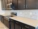 Contemporary kitchen featuring dark cabinets, stainless steel appliances, and bright white countertops at 7208 E Purple Prairie Dr, San Tan Valley, AZ 85143