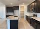 Bright kitchen featuring white countertops, dark cabinets, stainless steel appliances, and a pantry at 7208 E Purple Prairie Dr, San Tan Valley, AZ 85143