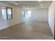 Spacious living room featuring neutral-toned tile floors and natural light from three windows at 7208 E Purple Prairie Dr, San Tan Valley, AZ 85143