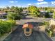 Community entry gate features a security booth, mature trees, and manicured landscaping at 7309 E Rovey Ave, Scottsdale, AZ 85250