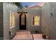 Charming courtyard entryway features a decorative black metal door, two windows, pavers, and drought-resistant plants at 7309 E Rovey Ave, Scottsdale, AZ 85250