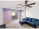 Cozy living room with plush blue sofa, ceiling fan, and sliding glass door at 7309 E Rovey Ave, Scottsdale, AZ 85250