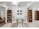 Dining area with glass table and four chairs, with bookshelves and decorative wall art at 9625 W Oak Ridge Dr, Sun City, AZ 85351