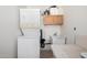 Laundry room featuring a stacked washer and dryer, utility sink, and overhead cabinets at 9625 W Oak Ridge Dr, Sun City, AZ 85351