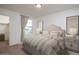 A serene bedroom features soft, patterned bedding, a window view, and elegant bedside table decor at 9819 W Agora Ln, Tolleson, AZ 85353