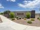 Community entrance to The Villages at Accomazzo with stone pillars, block wall and desert landscaping at 9819 W Agora Ln, Tolleson, AZ 85353