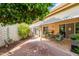 Well-maintained backyard with a covered patio, brick-paved area, and lush landscaping, perfect for outdoor enjoyment at 10443 W Loma Blanca Dr, Sun City, AZ 85351