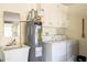 Functional laundry room with a utility sink, water heater, washer, dryer, and storage cabinets at 10443 W Loma Blanca Dr, Sun City, AZ 85351