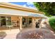 Inviting covered patio with outdoor seating, a barbecue grill, and a view of the landscaped brick-paved backyard at 10443 W Loma Blanca Dr, Sun City, AZ 85351
