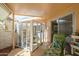 Enclosed patio area featuring a cat enclosure, outdoor seating, and access to the home through a sliding glass door at 10443 W Loma Blanca Dr, Sun City, AZ 85351