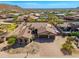 Aerial view of a desert home showcasing a circular turret, lush landscaping, and ample parking at 10649 E Saddle Blanket Trl, Gold Canyon, AZ 85118