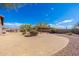Expansive desert backyard with gravel, mature trees, and view of a patio with outdoor seating area at 10649 E Saddle Blanket Trl, Gold Canyon, AZ 85118