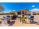 Outdoor kitchen and barbecue areas on brick paver patio surrounded by lush desert landscaping at 10649 E Saddle Blanket Trl, Gold Canyon, AZ 85118
