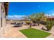 Well maintained backyard with desert landscaping, a patch of green lawn, and a covered patio with seating at 10649 E Saddle Blanket Trl, Gold Canyon, AZ 85118