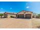Large driveway leads to a three-car garage with mature desert landscaping at 10649 E Saddle Blanket Trl, Gold Canyon, AZ 85118