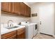 Well-equipped laundry room features modern washer, dryer, storage and neutral tile flooring at 10649 E Saddle Blanket Trl, Gold Canyon, AZ 85118