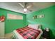 Inviting bedroom with bright green walls, ceiling fan, and plush bed, perfect for rest and relaxation at 11509 E Marguerite Ave, Mesa, AZ 85208