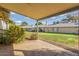 View from the covered back patio, showcasing the landscaped backyard and neighboring homes at 11671 S Jokake St, Phoenix, AZ 85044