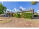 Exterior shot of the home, featuring a covered patio and green landscaping at 11671 S Jokake St, Phoenix, AZ 85044