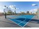 Well-maintained community basketball court with bright blue surface, new hoops, and surrounding greenery at 11671 S Jokake St, Phoenix, AZ 85044