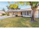 Single-story home with covered carport, well maintained lawn and mature shade tree in the front yard at 11671 S Jokake St, Phoenix, AZ 85044